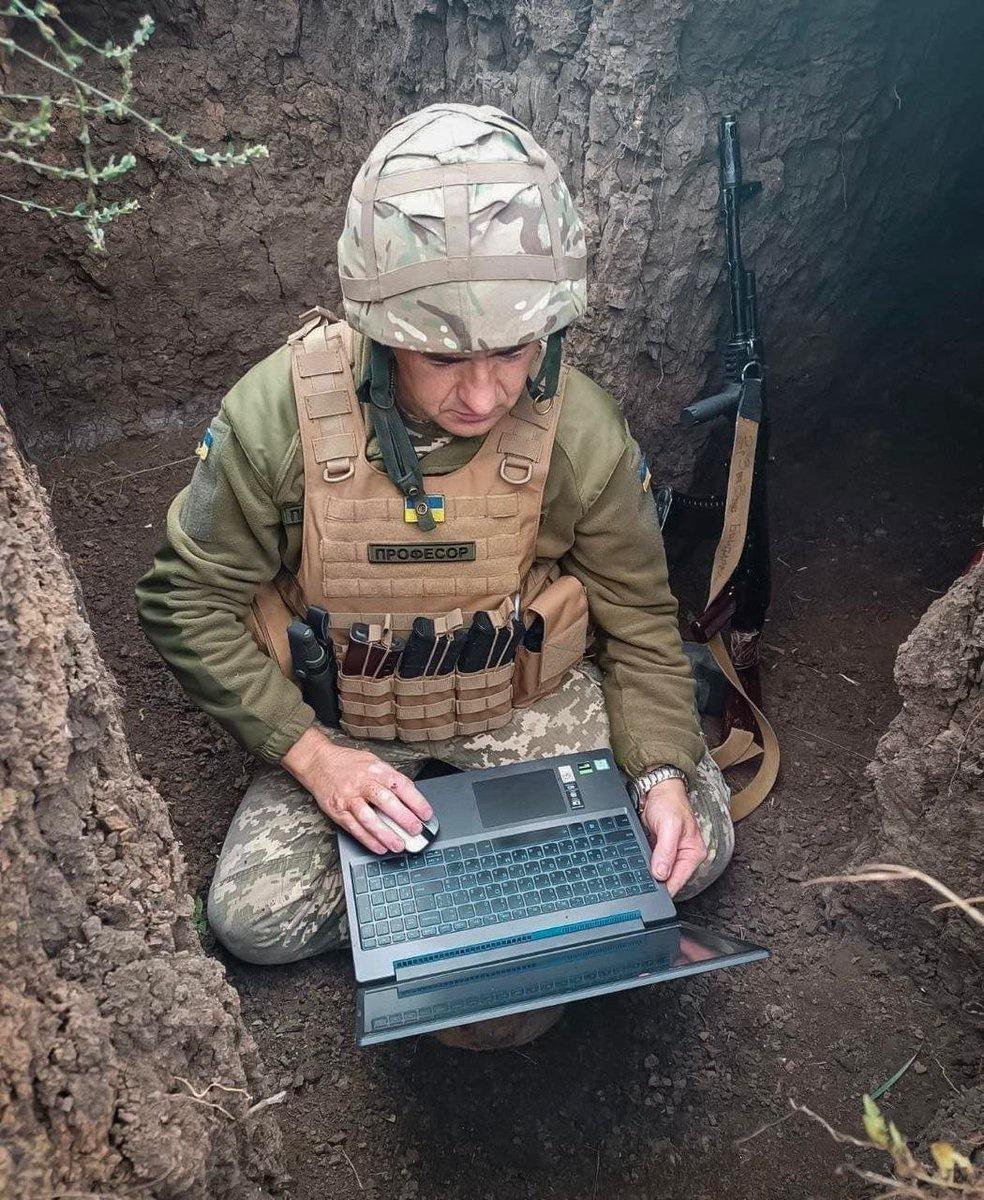 A soldier of the 123rd Mykolaiv Brigade, name signal “Professor” consults his students online passable from the trenches.